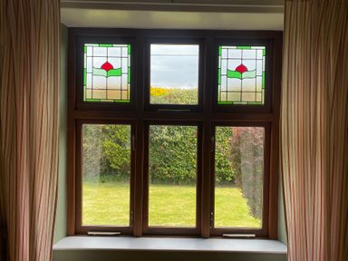 A window with stained glass and garden view at Kenvor Newport, Pembrokeshire
