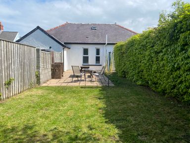 A garden with patio furniture and fence at Kenvor Newport, Pembrokeshire