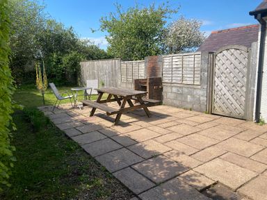 A garden with a patio table and chairs at Kenvor in Newport, Pembrokeshire