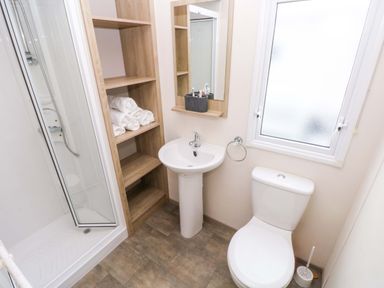 A bathroom featuring a shower, toilet, and sink at 82 Manorbier Park in Manorbier