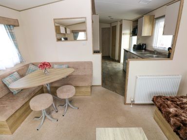 A living room with a table and sofa at 82 Manorbier Park in Manorbier