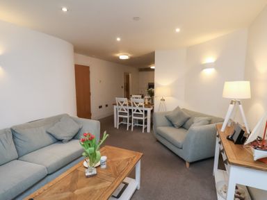 A living room with a sofa and dining area at One Union Mill - garden apartment Whitby