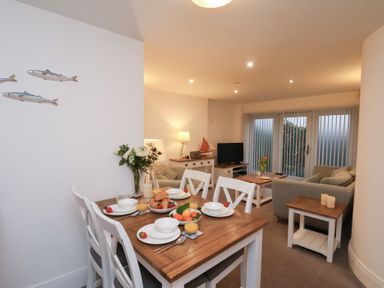 A dining area with a table and chairs at One Union Mill - garden apartment Whitby