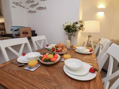 A dining room table set with fruit and croissants at One Union Mill - garden apartment Whitby