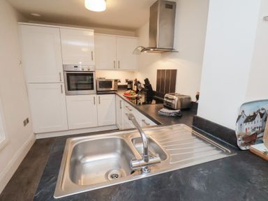 A kitchen with appliances including an oven and microwave at One Union Mill - garden apartment Whitby