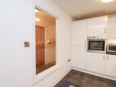 A kitchen with an oven and cabinets at One Union Mill - garden apartment in Whitby
