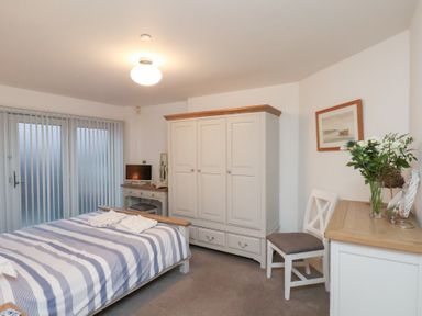 A bedroom with a bed and wardrobe at One Union Mill - garden apartment Whitby