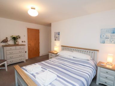A bedroom with a bed, bedside table, and chest of drawers at One Union Mill - garden apartment in Whitby