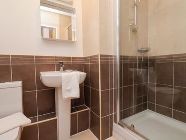 A bathroom with a shower and sink at One Union Mill - garden apartment in Whitby