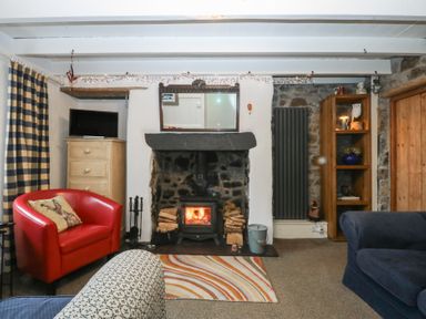 A living room featuring a fireplace and two seating areas at Parc y Brenin Holidays, Abersoch