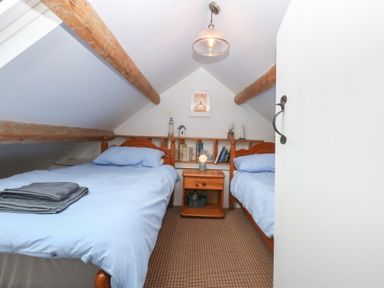 A bedroom with two beds and a bedside table at Parc y Brenin Holidays, Abersoch