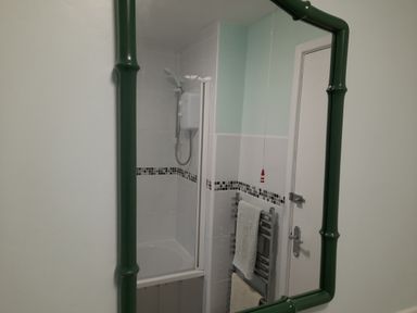 A bathroom with a shower and towel rack at Parc y Brenin Holidays, Cilan near Abersoch