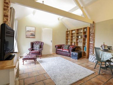 A living room with a television and sofas at Ivy Barn in Norwich