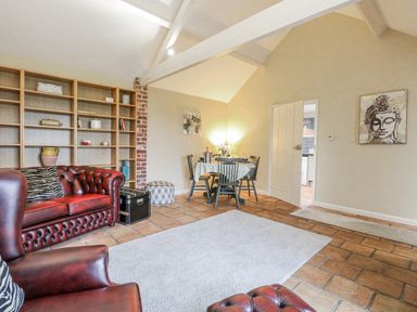 A living room with a sofa and dining table at Ivy Barn in Norwich