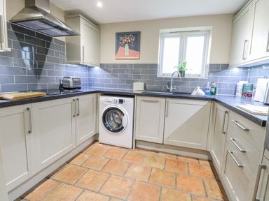 A kitchen with a washing machine and sink at Ivy Barn in Norwich