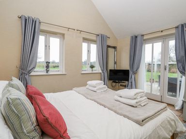 A bedroom with a bed and towels on top at Ivy Barn in Norwich