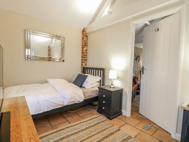 A bedroom with a bed and lamp at Ivy Barn in Norwich