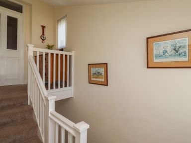 A stairwell featuring a staircase and framed pictures at Kittiwake at No 20 Seahouses