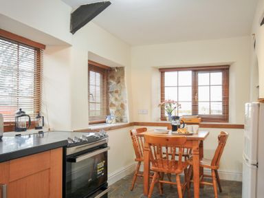 A kitchen with a table and chairs at Little Blagdon in Beaworthy