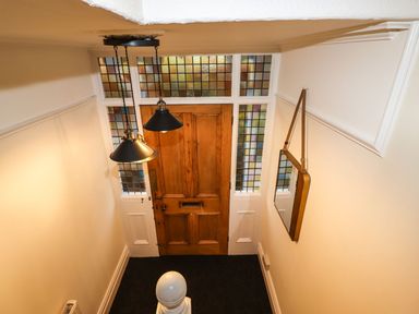 A hallway with a wooden door and stained glass windows at Waterhead Cottage in Ambleside