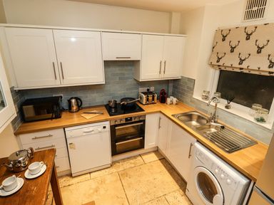 A kitchen with appliances and a washing machine at Waterhead Cottage in Ambleside
