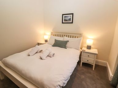 A bedroom with a bed and nightstand at Waterhead Cottage in Ambleside