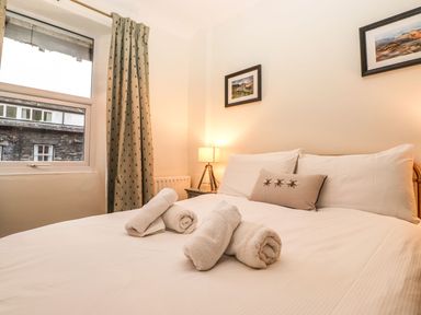 A bedroom with a bed, pillows, and a lamp at Waterhead Cottage in Ambleside