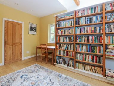 A study with a bookshelf and table at Inglewood Bach in Conwy