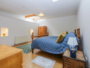 A bedroom with a bed and furniture at Inglewood Bach in Conwy