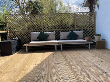 A seating area with a sofa and planters at Inglewood Bach in Conwy