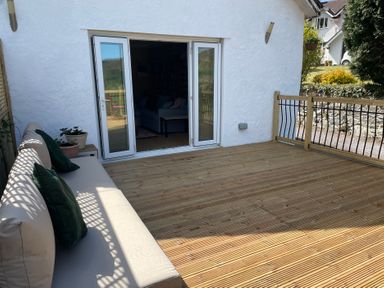 An outdoor area with a sofa and potted plant at Inglewood Bach in Conwy