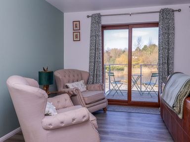 A living room with chairs and a sliding door at Star Carr Lakes