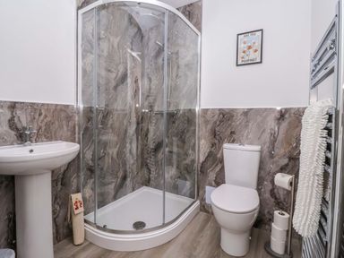 A bathroom with a shower, sink, and toilet at Star Carr Lakes