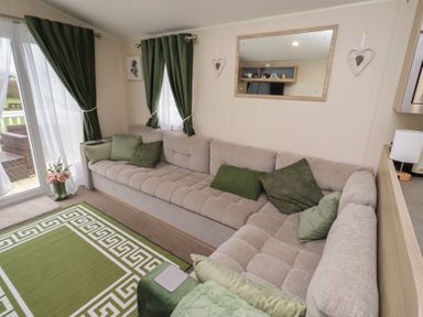 A living room with a sofa and window at Homeslea 33 Millennium Gardens in Morpeth