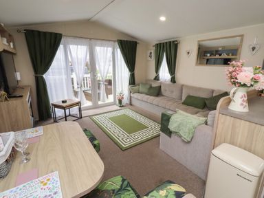A living room with a sofa and table at Homeslea 33 Millennium Gardens, Morpeth