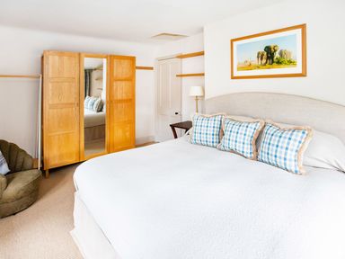 A bedroom with a bed and wardrobe at Gardeners Cottage in Chipping Norton