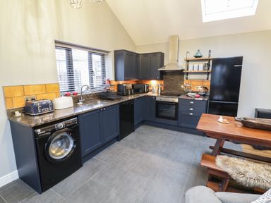 A kitchen with appliances and a dining area at Otter's Rest in Droitwich