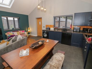 A kitchen with a dining table and appliances at Otter's Rest in Droitwich