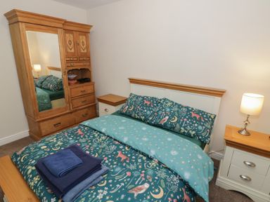 A bedroom with a bed and wardrobe at Otter's Rest in Droitwich