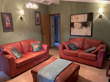 A living room with two sofas and wall art at The Hermitage in Penrith