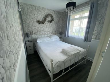 A bedroom with a bed and bedside tables at Chalet 58, California, Norfolk