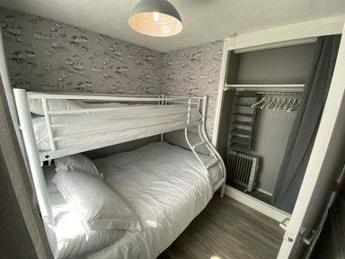 A bedroom with a bunk bed and a double bed at Chalet 58 in California, Norfolk