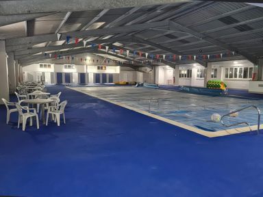 An indoor pool area with tables and chairs at Chalet 58 California, Norfolk