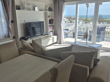 A living room with a television and sofa at 21 Gorse Hill in Exmouth