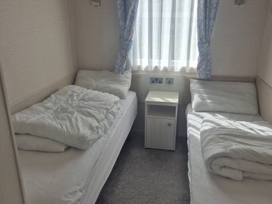 A bedroom with two single beds and a bedside table at 21 Gorse Hill Exmouth