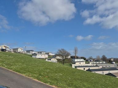 A view of mobile homes on a hill with grass at 21 Gorse Hill in Exmouth