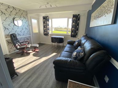 A living room with a chair and table at Chalet 333 in California, Norfolk