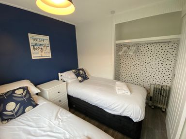 A bedroom with two beds and a wardrobe at Chalet 333, California, Norfolk