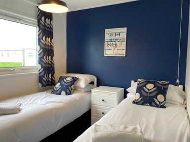 A bedroom with two beds and a nightstand at Chalet 333 in California, Norfolk