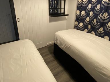 A bedroom with two beds and a curtain at Chalet 333 in California, Norfolk
